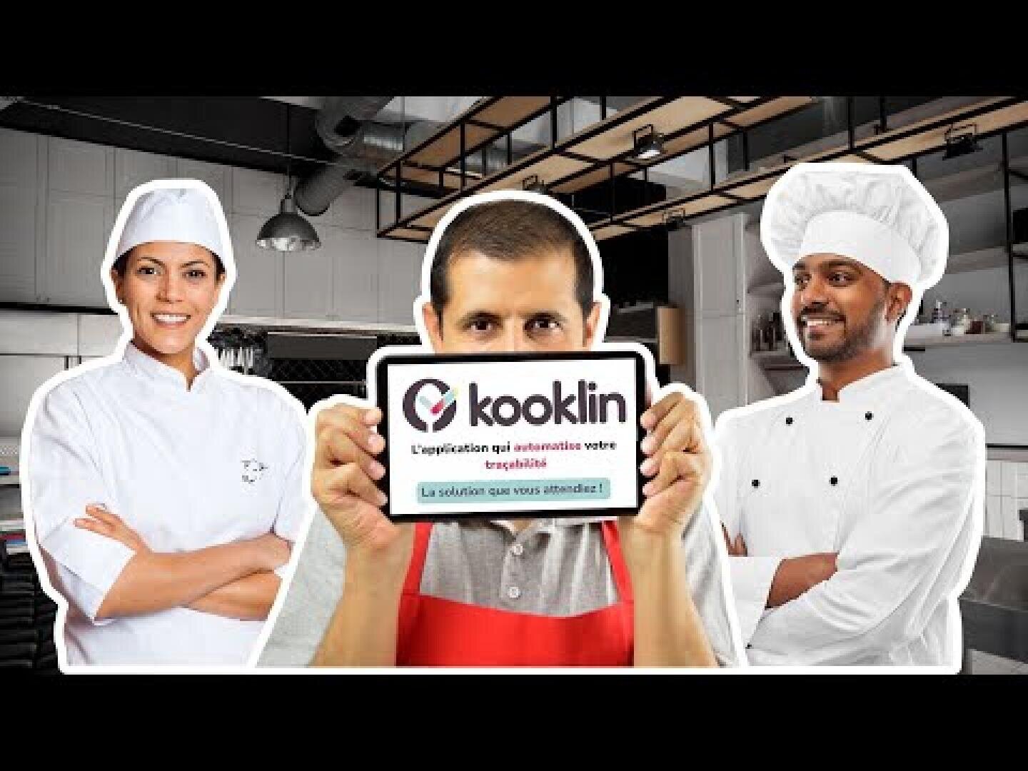 Drei Köche in einer Großküche; der Koch in der Mitte hält eine Tafel mit dem Logo und dem Slogan von Kookin, während die beiden anderen Köche lächelnd daneben stehen.