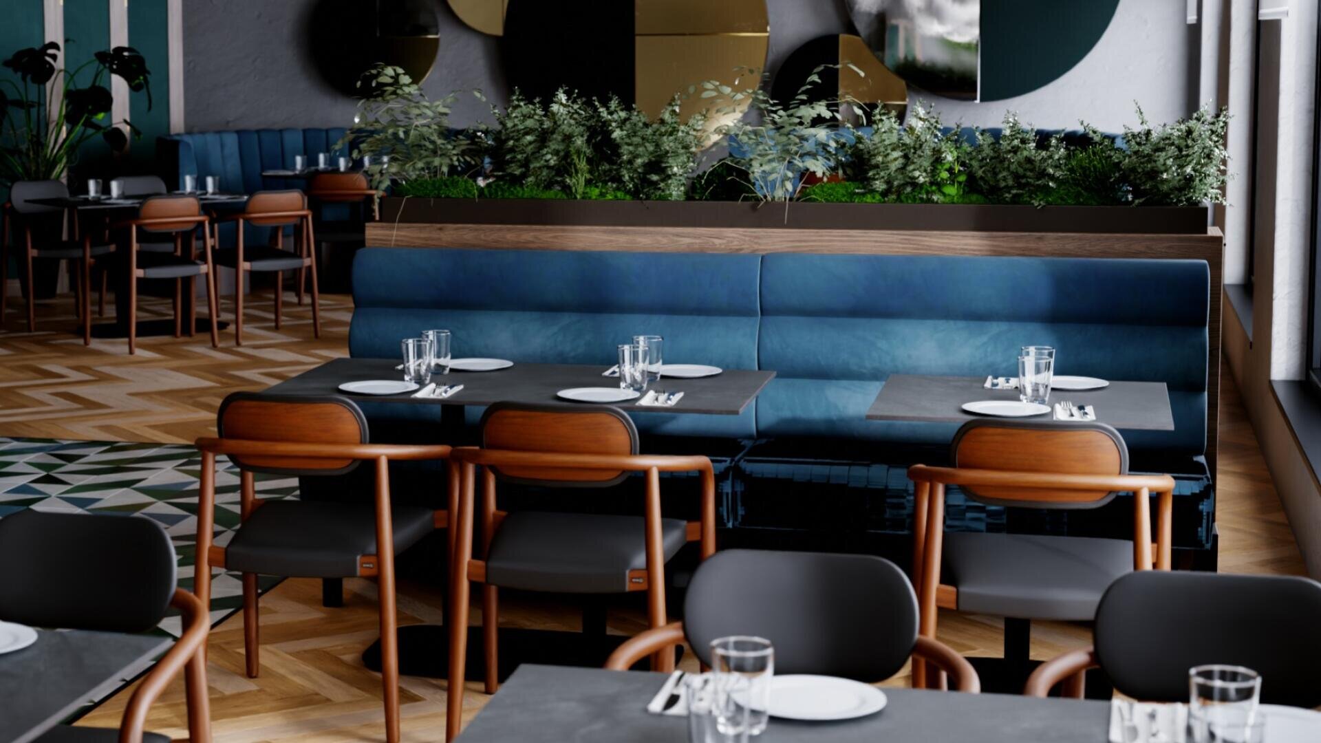 Un restaurant moderne avec des banquettes bleues rembourrées, des tables sombres avec des assiettes et des verres, des chaises en bois et des plantes vertes en guise de cloisons. La salle est bien éclairée et le sol est recouvert d'un revêtement à motifs géométriques.