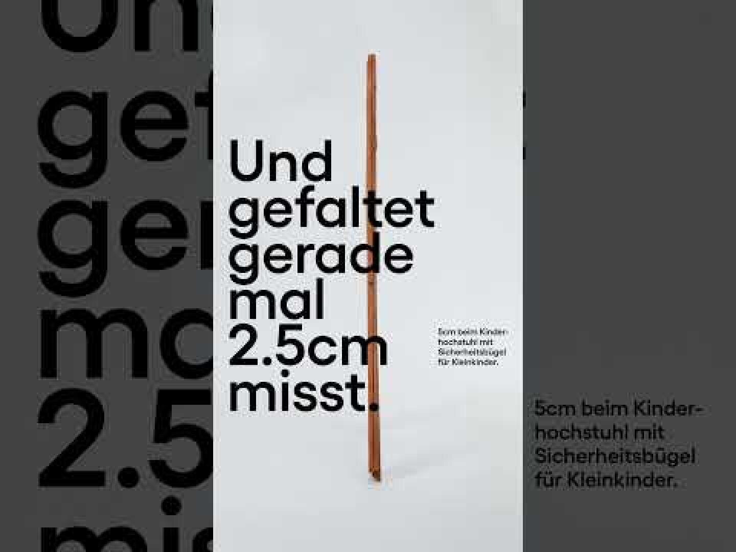Une chaise haute en bois est pliée de manière à ce qu'elle tienne debout et ne mesure que 2,5 cm de large. Le grand texte allemand "Und gefaltet gerade mal 2,5 cm messt" souligne sa compacité. Un texte plus petit décrit les caractéristiques de sécurité pour les enfants.