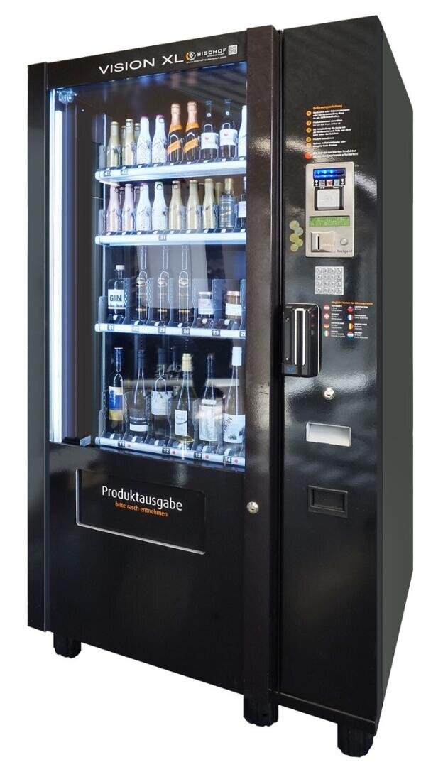 Ein schwarzer Verkaufsautomat mit der Aufschrift Vision XL stellt auf beleuchteten Regalen verschiedene Flaschen mit alkoholischen Getränken, darunter Bier, Wein und Spirituosen, aus. Auf der rechten Seite befindet sich das Bedienfeld mit Tasten und einem Zahlungsschlitz.