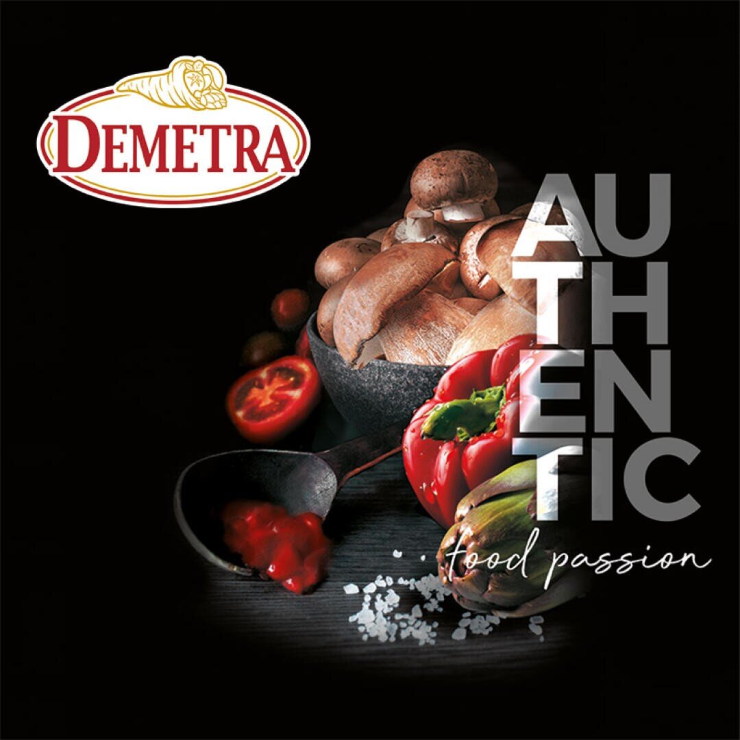 Un fond sombre avec des champignons, un poivron rouge, un artichaut, du sel et de la sauce tomate, avec le logo Demetra et les mots AUTHENTIC food passion en caractères blancs gras.