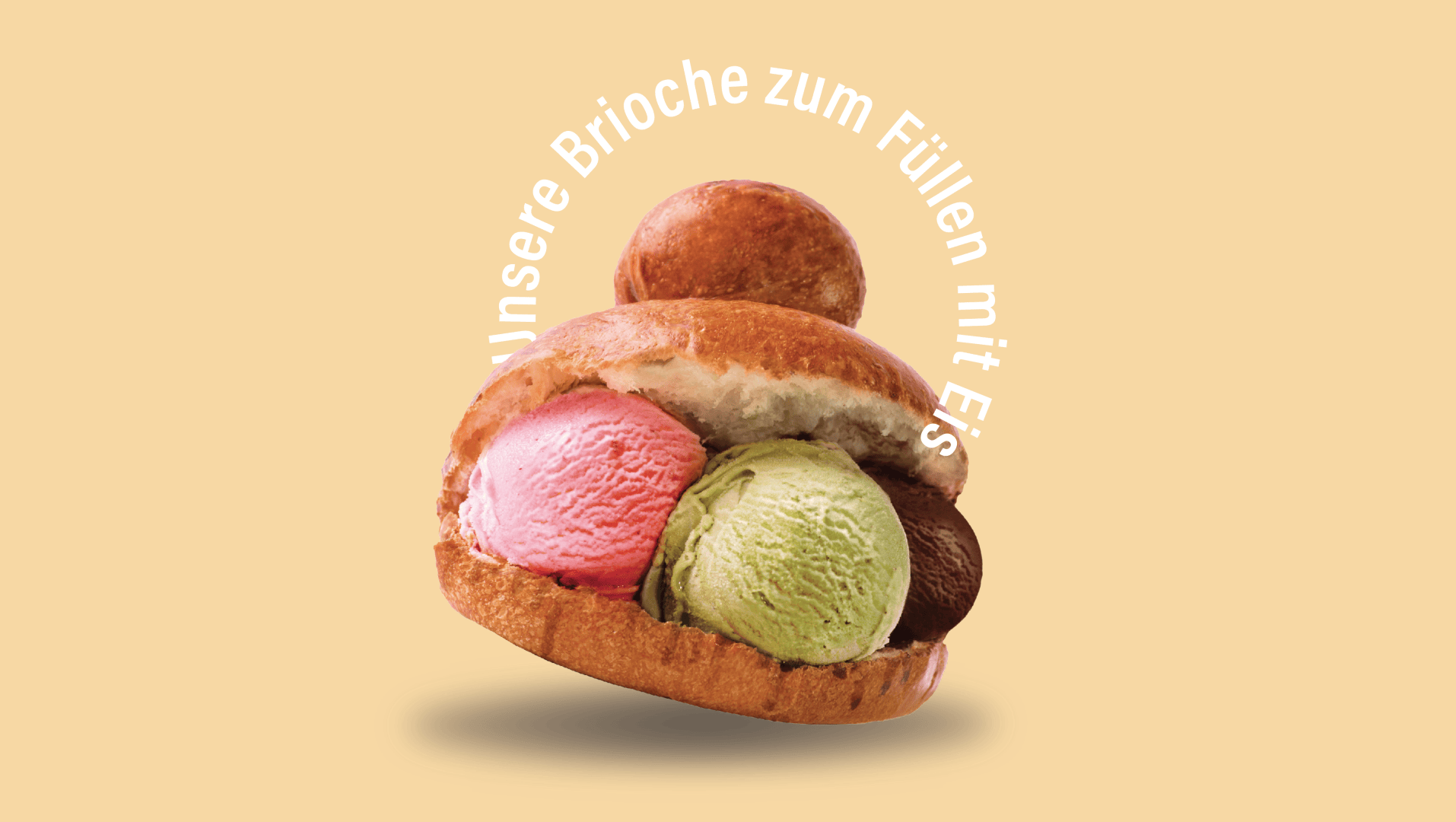 Ein Brioche-Brötchen, gefüllt mit drei Kugeln Eis in Rosa, Grün und Braun, mit einem weiteren Brötchen obenauf. Der deutsche Text umrundet das Bild und lautet: "Unsere Brioche zum Füllen mit Eis".