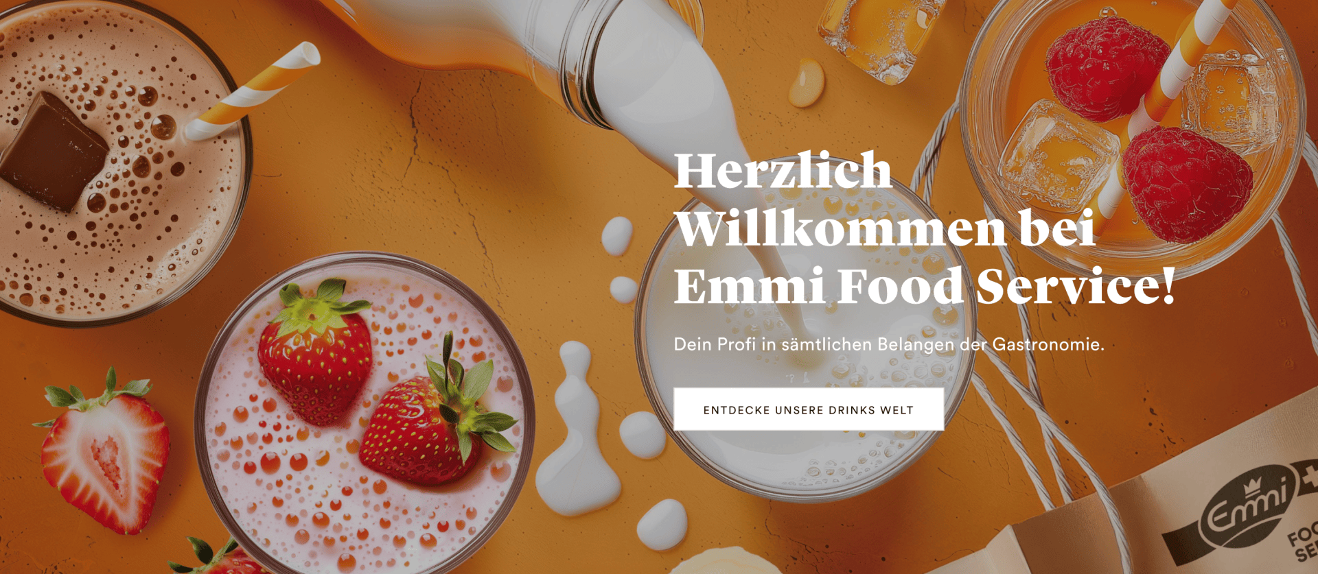 Vue de haut de plusieurs verres remplis de boissons à base de lait, garnis de fraises et de framboises, et du lait versé. Le texte de l'image indique "Herzlich Willkommen bei Emmi Food Service !" avec un bouton en dessous.