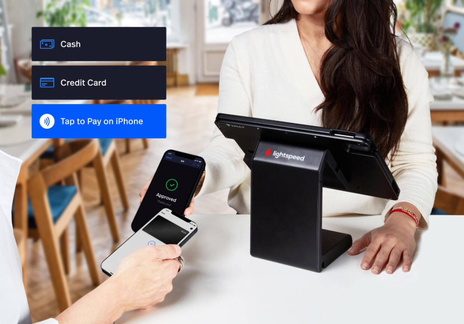 Eine Person bezahlt an einem Schalter mit der Tap to Pay-Funktion ihres Telefons auf einem iPhone, während eine andere Person ein POS-Terminal bedient. Die Zahlungsoptionen - Bargeld, Kreditkarte, Tap to Pay - sind links dargestellt.