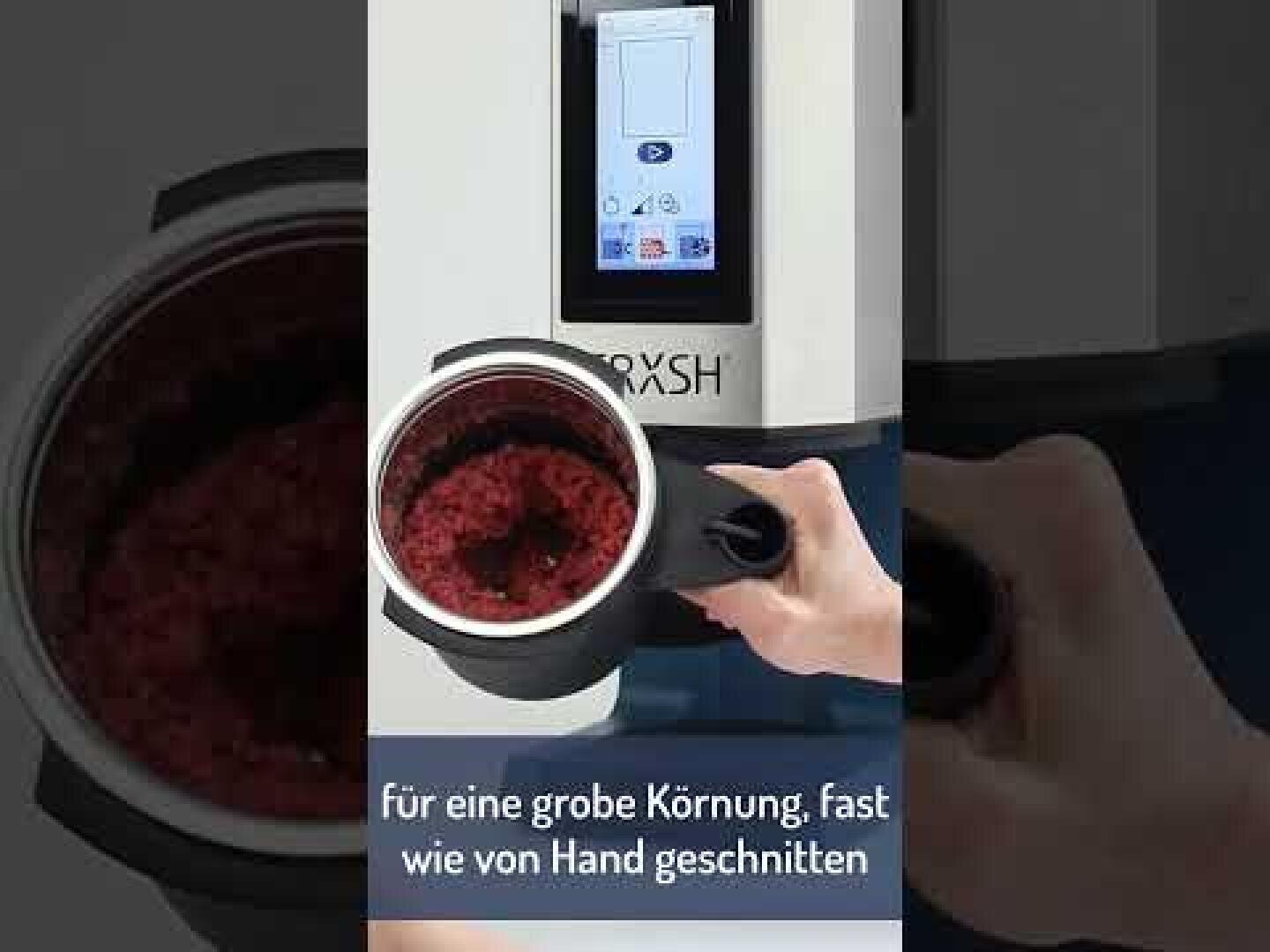 Une personne tient un bol rempli de viande hachée d'un robot ménager devant un appareil de cuisine à affichage numérique. Le texte allemand en bas de l'écran indique : "Pour une granulation grossière, presque comme si elle était coupée à la main.