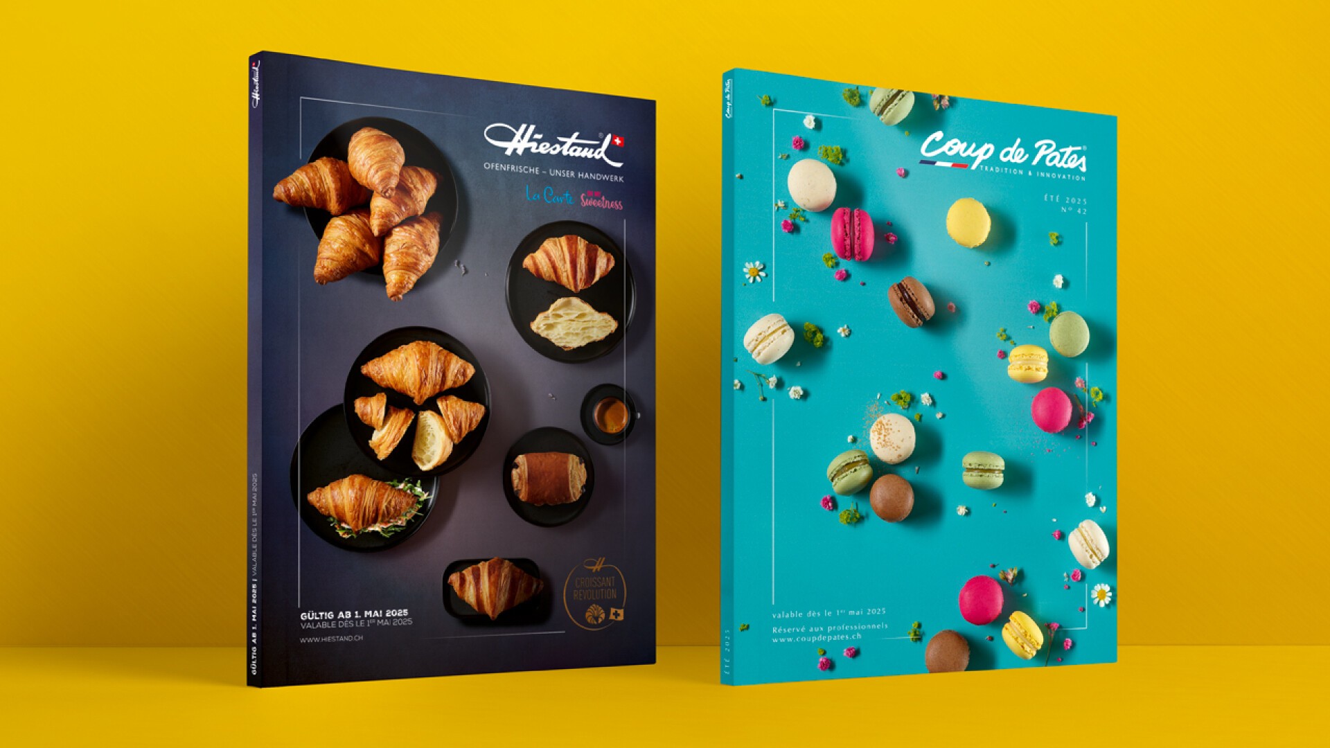 Zwei farbenfrohe Backmagazine stehen aufrecht vor gelbem Hintergrund. Das linke Cover zeigt Croissants auf dunklem Hintergrund, während das rechte verschiedene Macarons und Blumen auf hellblauem Hintergrund zeigt.