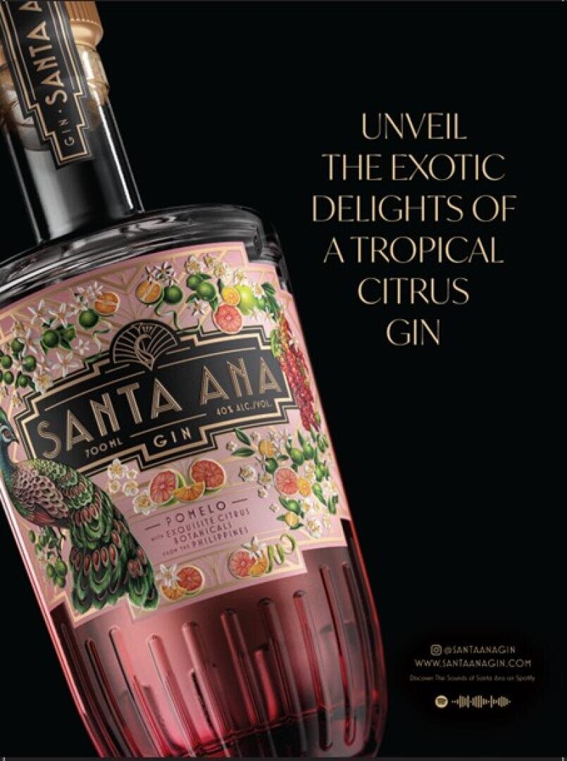 Gros plan sur une bouteille de gin Santa Ana avec une étiquette colorée représentant des fruits tropicaux et un paon. À côté, on peut lire en lettres dorées : Découvrez les délices exotiques d'un gin aux agrumes tropicaux.