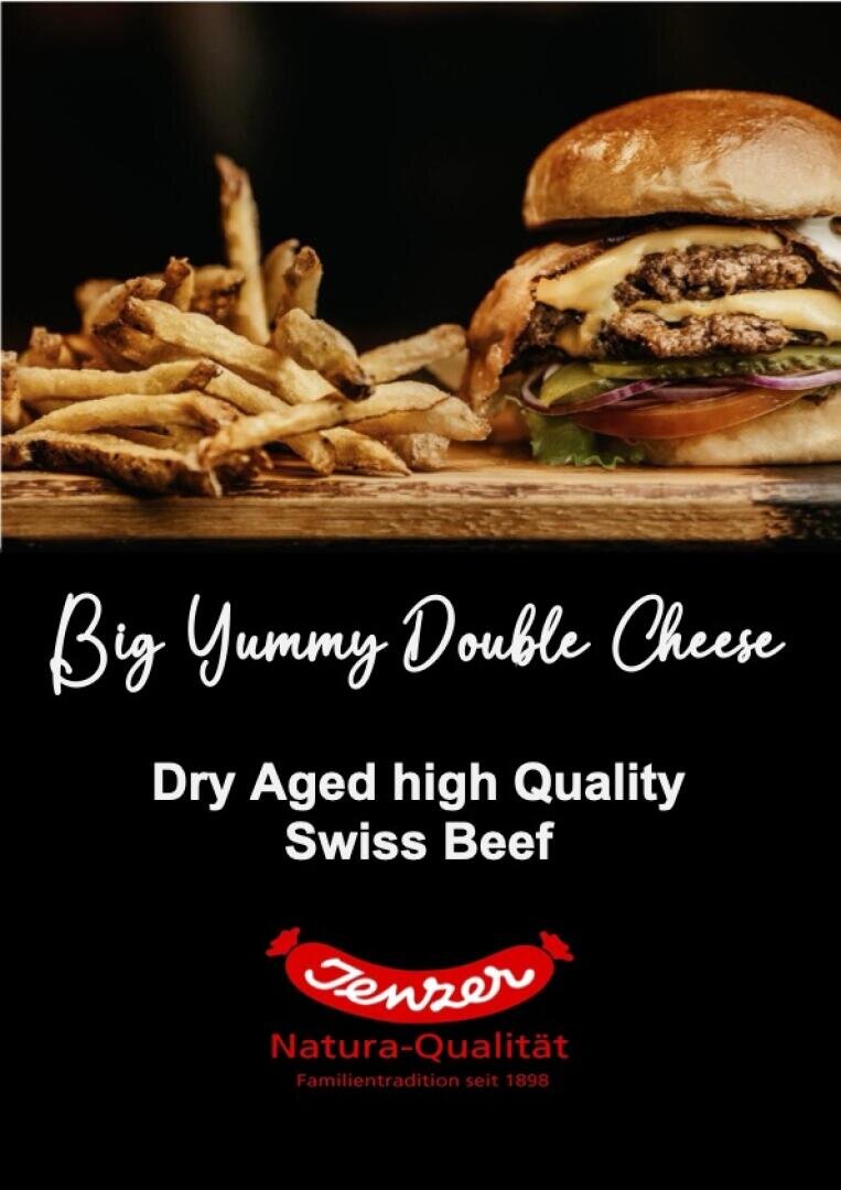 Ein Cheeseburger mit Salat, Tomate und roten Zwiebeln neben einem Stapel Pommes frites. Der Text darunter lautet: "Big Yummy Double Cheese. Dry Aged High Quality Swiss Beef." Unten steht das Markenlogo "Jemzer Natura-Qualität".