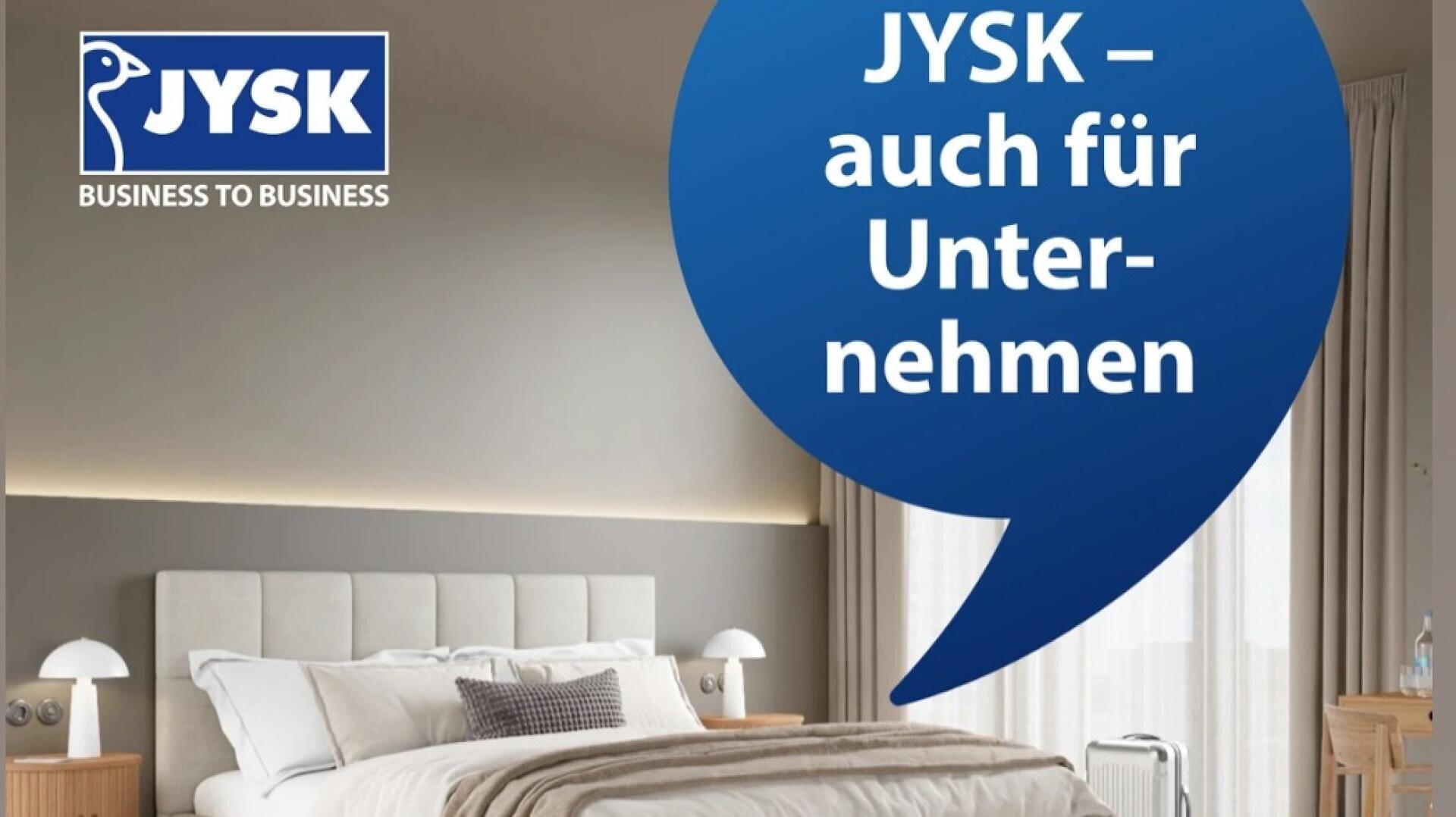 Ein modernes, sauber gemachtes Bett mit weißer und beiger Bettwäsche in einem stilvollen Raum. In einer blauen Sprechblase steht JYSK - auch für Unternehmen. Das JYSK Business to Business Logo erscheint in der oberen linken Ecke.