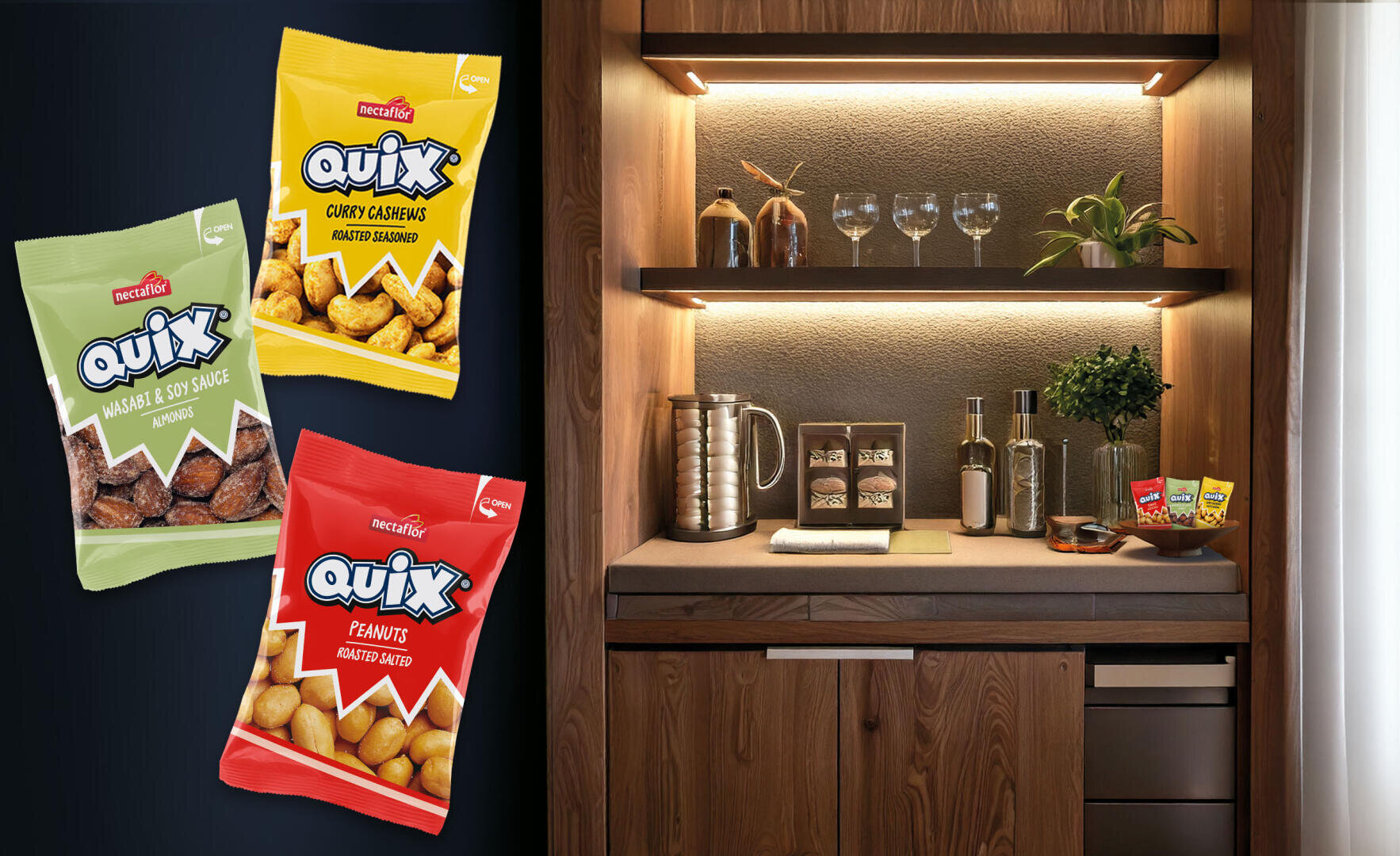 Drei bunte Quix-Snackpakete schweben neben einer modernen Minibar aus Holz, die mit Gläsern, einem Wasserkocher, Tassen und Flaschen bestückt ist und eine gemütliche und einladende Atmosphäre schafft.