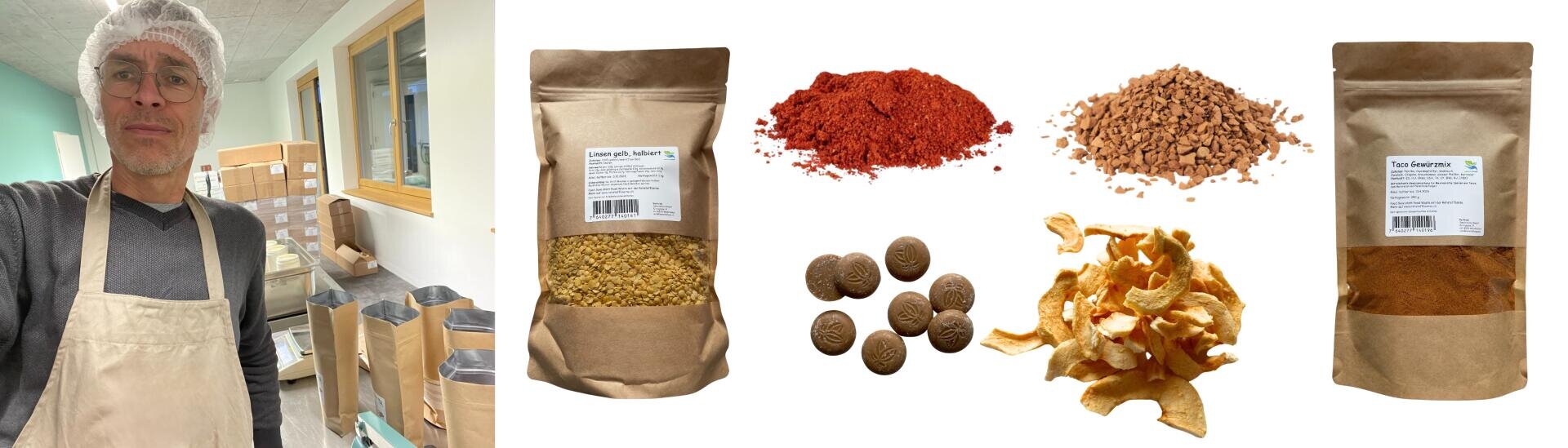 Un homme portant un filet à cheveux et un tablier se tient dans une zone de travail remplie de sacs et de caisses. À côté de lui, des paquets et des piles d'ingrédients séchés, de poudres et de chips sont posés sur un fond blanc.