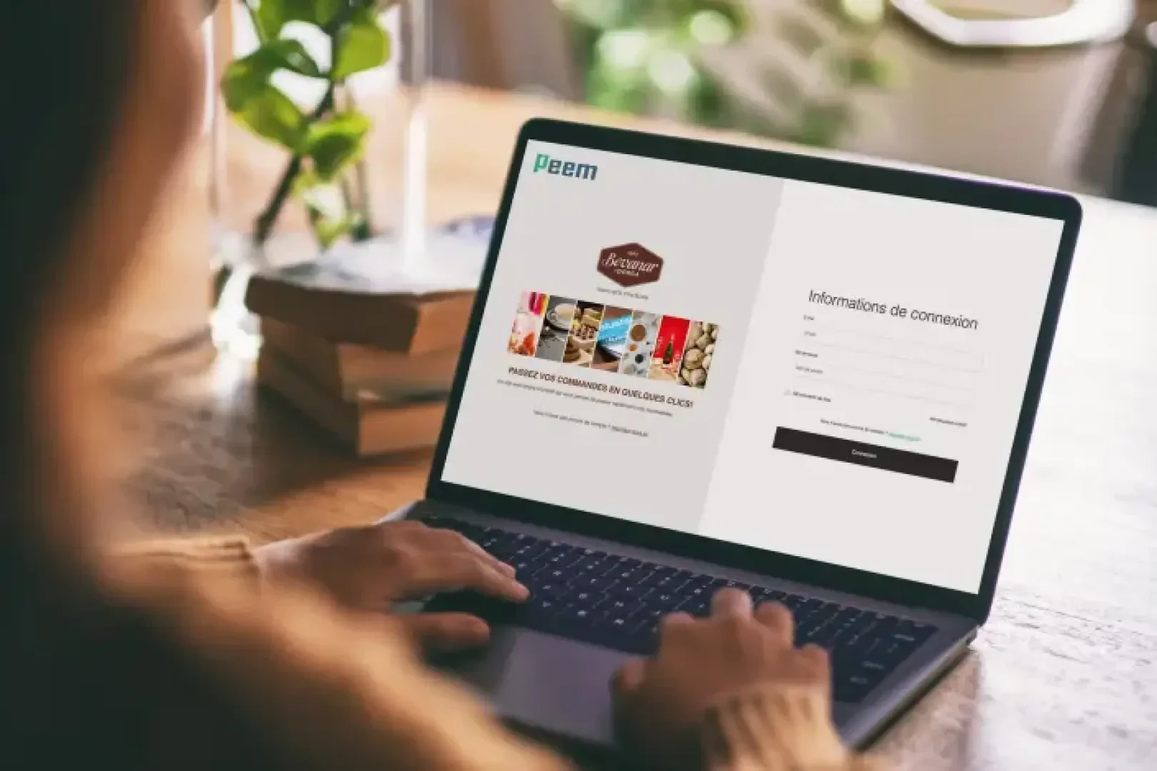 Eine Person benutzt einen Laptop, auf dem eine Anmeldeseite für eine Website namens Peem angezeigt wird, mit Feldern für E-Mail und Passwort und einem Werbebanner auf der linken Seite. Auf dem Schreibtisch befinden sich Bücher und eine Pflanze.