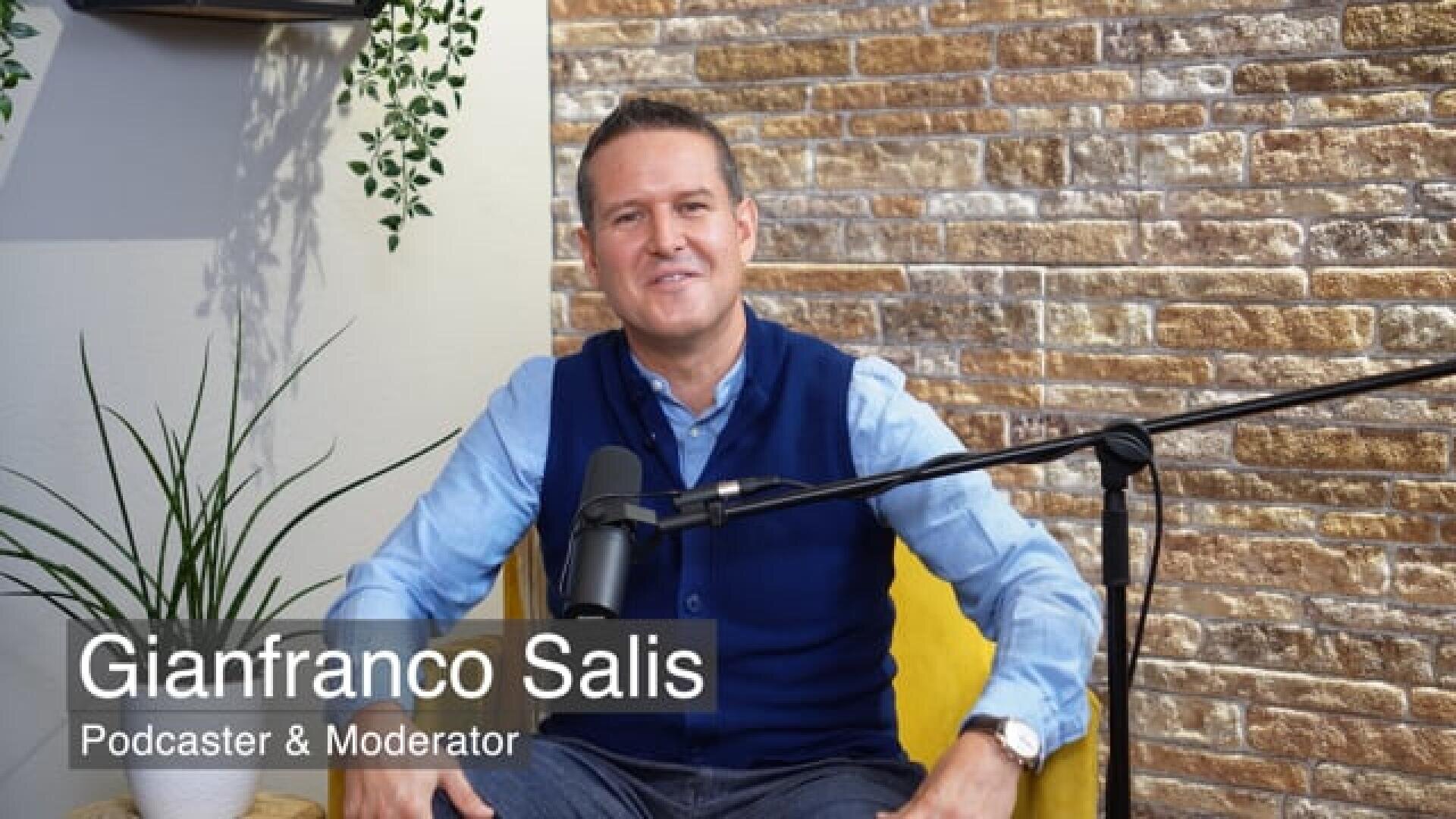 Ein Mann sitzt auf einem gelben Stuhl vor einem Mikrofon und lächelt in die Kamera. Der Text auf dem Bild lautet Gianfranco Salis, Podcaster & Moderator. Im Hintergrund sind eine Backsteinmauer und eine Pflanze zu sehen.