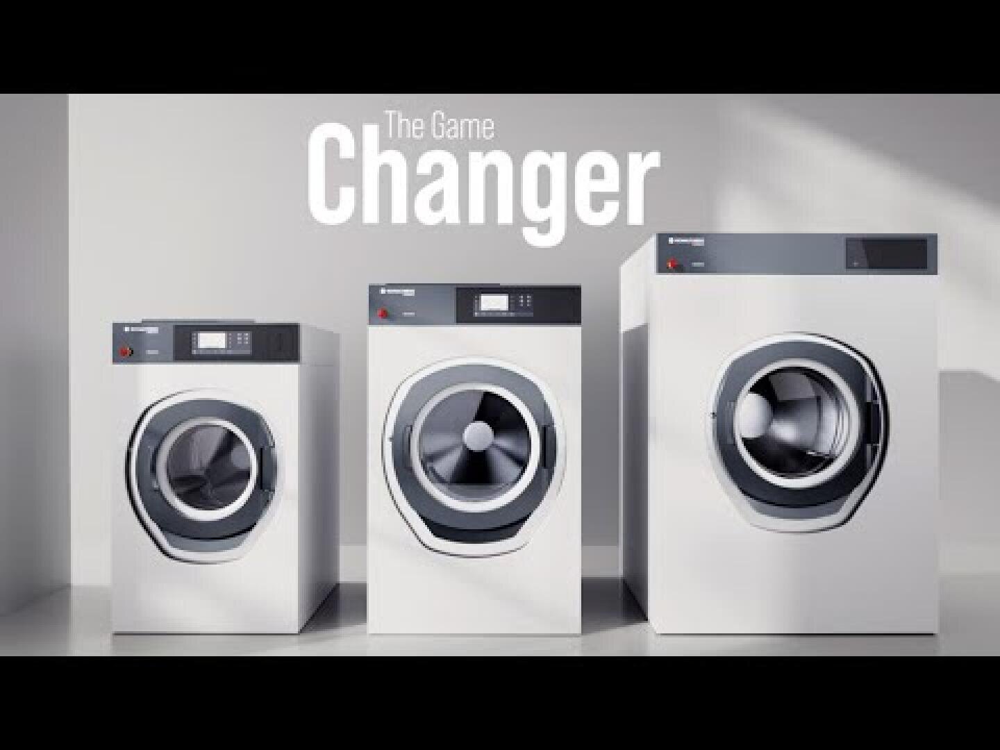 Drei moderne Frontlader-Waschmaschinen unterschiedlicher Größe sind nebeneinander in einem hellen, schlichten Raum ausgestellt. Der große Text darüber lautet "The Game Changer" (Das Spiel ändern).