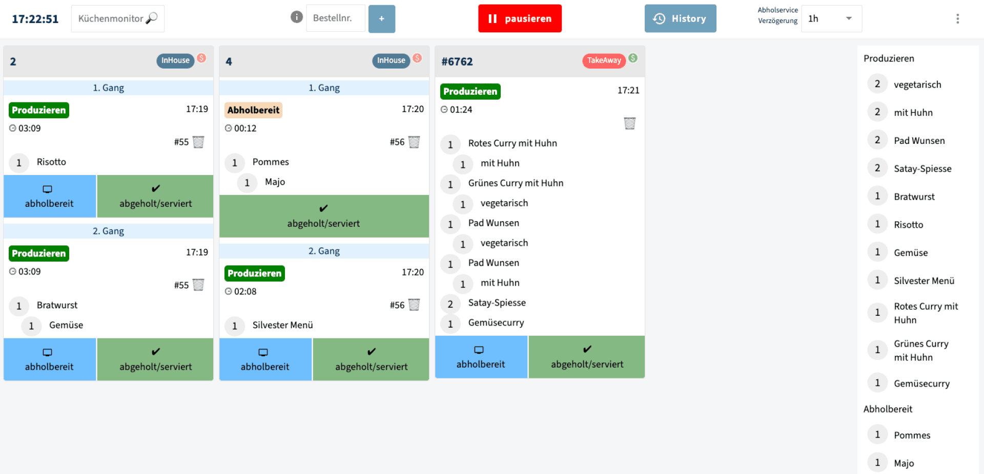 Ein digitaler Küchenauftragsmonitor zeigt mehrere Essensbestellungen mit Artikellisten, farbigen Statusetiketten und Zeitstempeln an. In der rechten Seitenleiste sind verschiedene Menükategorien und Bestellungen aufgeführt, darunter vegetarische Gerichte, Fleisch und Beilagen.
