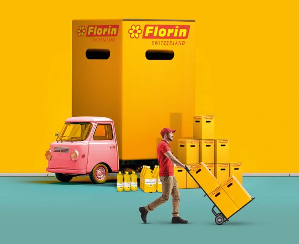 Ein Mann in rotem Hemd und Mütze schiebt eine gelbe Kiste auf einer Sackkarre. Hinter ihm stehen große gelbe Kisten mit der Aufschrift Florin Switzerland, ein rosafarbener Lieferwagen und Flaschen vor einem leuchtend gelben Hintergrund.