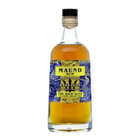 Une bouteille de rhum Maund avec un liquide brun doré, portant une étiquette colorée bleue et jaune sur laquelle on peut lire Maund Rum, Handcrafted-Unfiltered, Barbados, Swiss Single Cask Finish, The Wild Alps, Alchemy Adventure.
