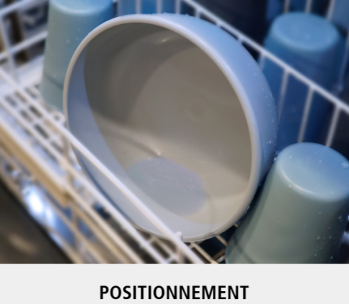 Un bol bleu clair est placé face à l'extérieur sur le panier supérieur d'un lave-vaisselle, entouré de tasses bleues placées à l'envers. Le mot POSITIONNEMENT apparaît en bas de l'image.