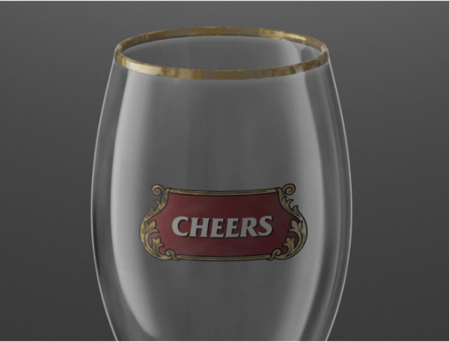 Un verre transparent à bord doré porte une étiquette rouge et or indiquant CHEERS en lettres blanches, sur un fond gris uni.