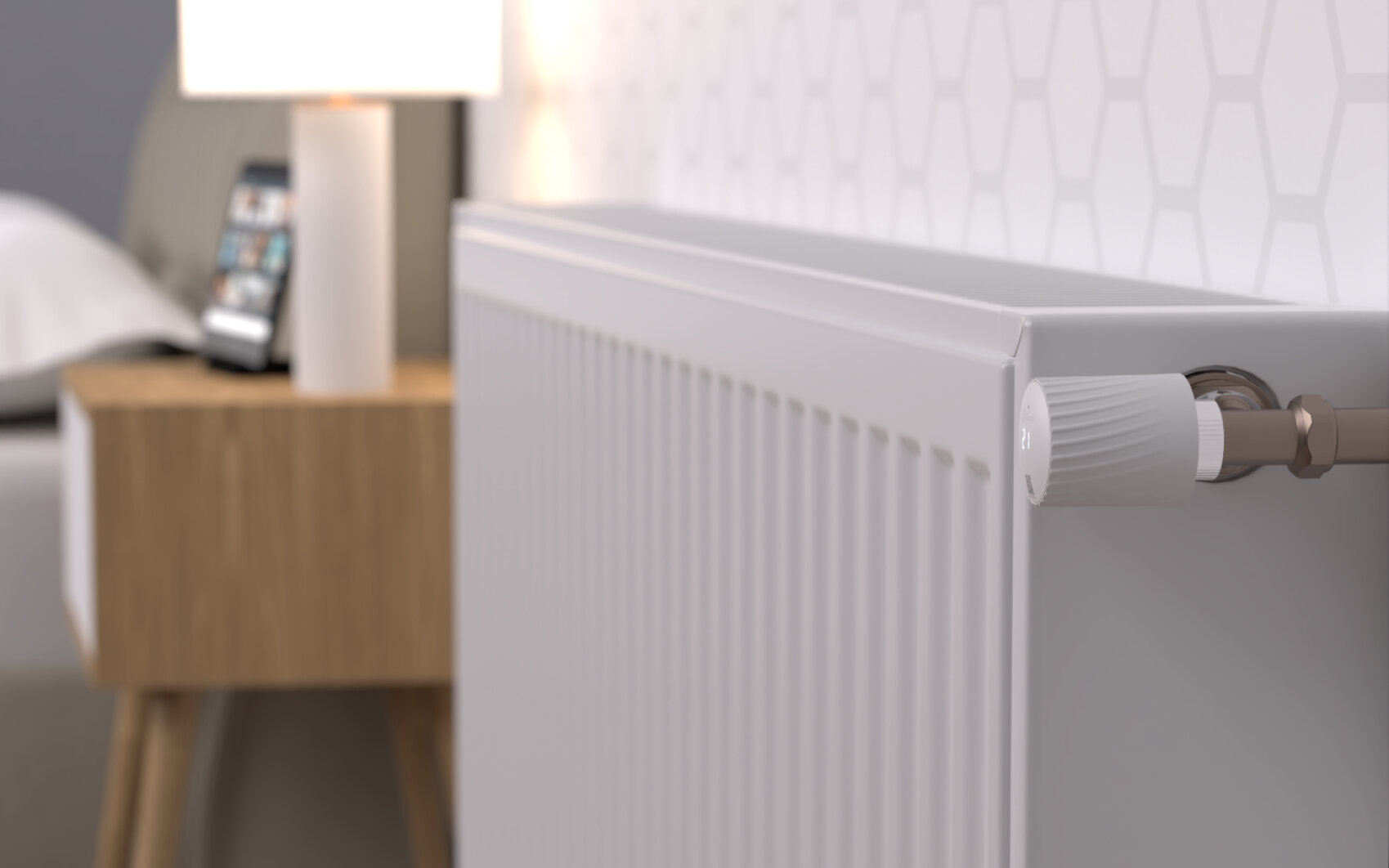 Nahaufnahme eines weißen Heizkörpers mit einem Temperaturregler in einem modernen Schlafzimmer. Im Hintergrund befindet sich ein hölzerner Nachttisch mit einer Lampe und einem Telefon darauf. Die Wand weist ein dezentes geometrisches Muster auf.